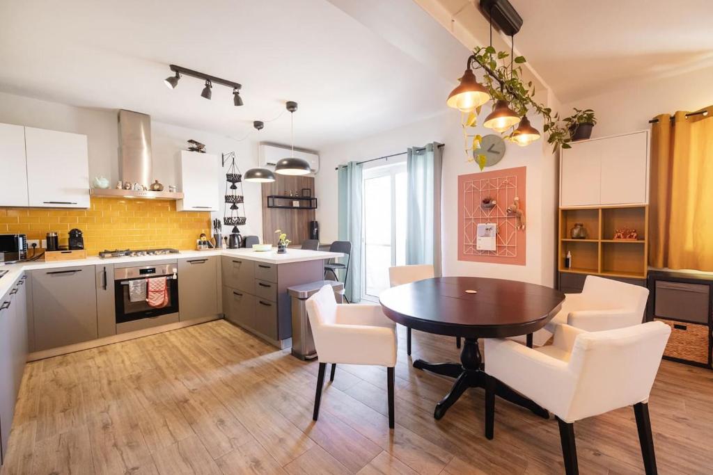 a kitchen and dining room with a table and chairs at Rinella beach house in Birgu