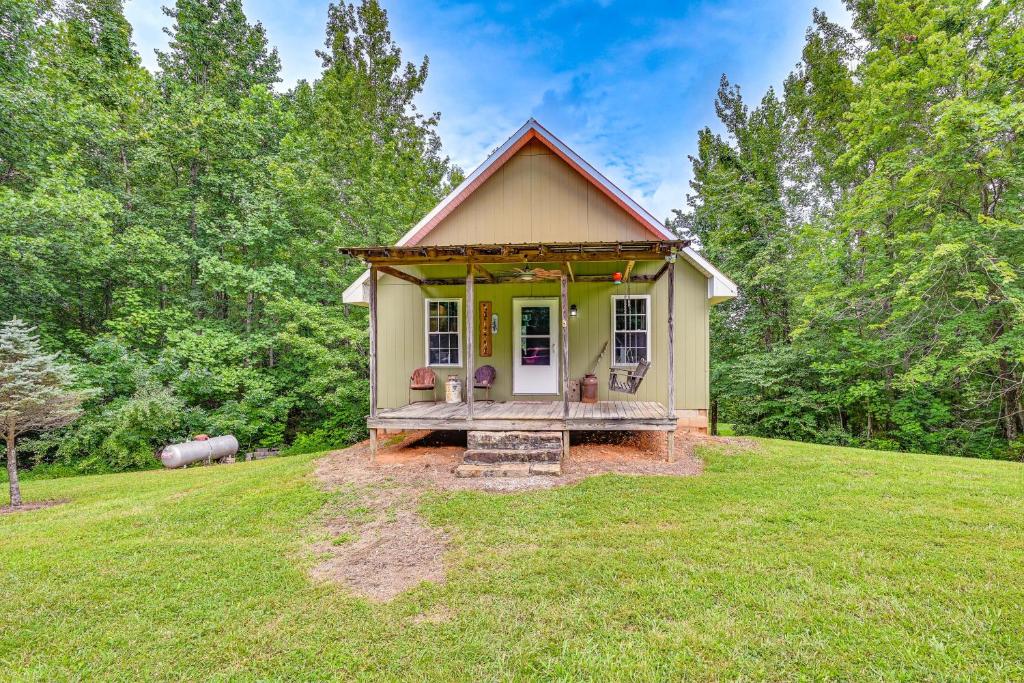 una pequeña casa amarilla con un porche en un campo en Kentucky Cabin Retreat with Covered Porch and Views, en Lewisburg