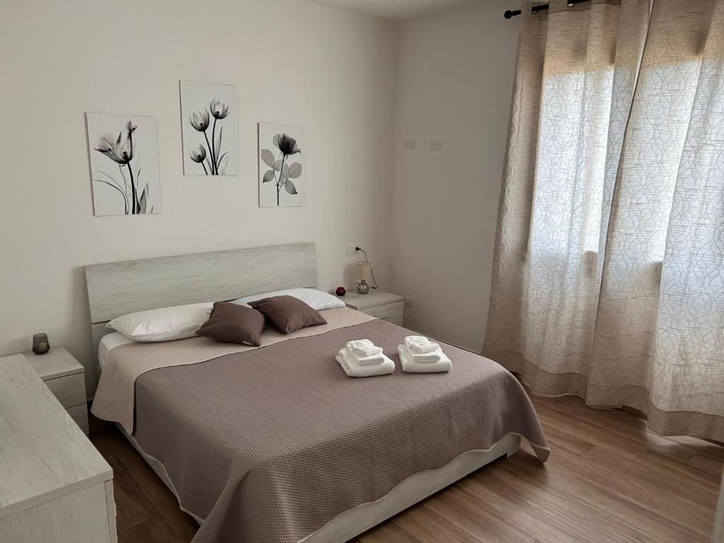 a bedroom with a bed with two towels on it at Villa pirastu in Bassacutena