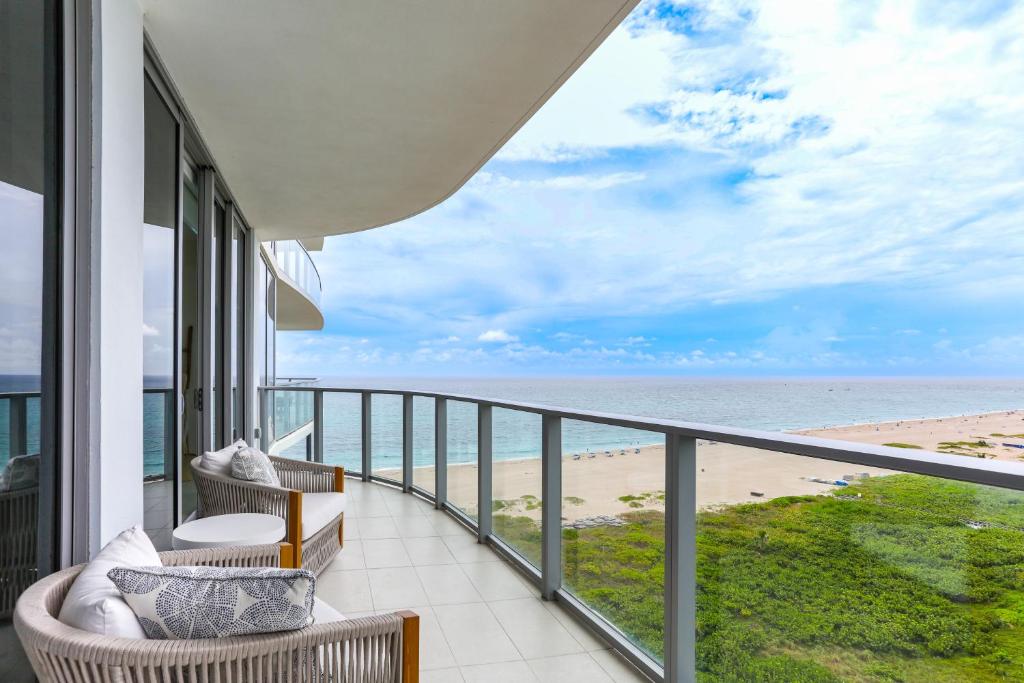 Un balcón con sillas y vista a la playa. en Ocean Views and Pool Access Riviera Beach Condo!, en Riviera Beach