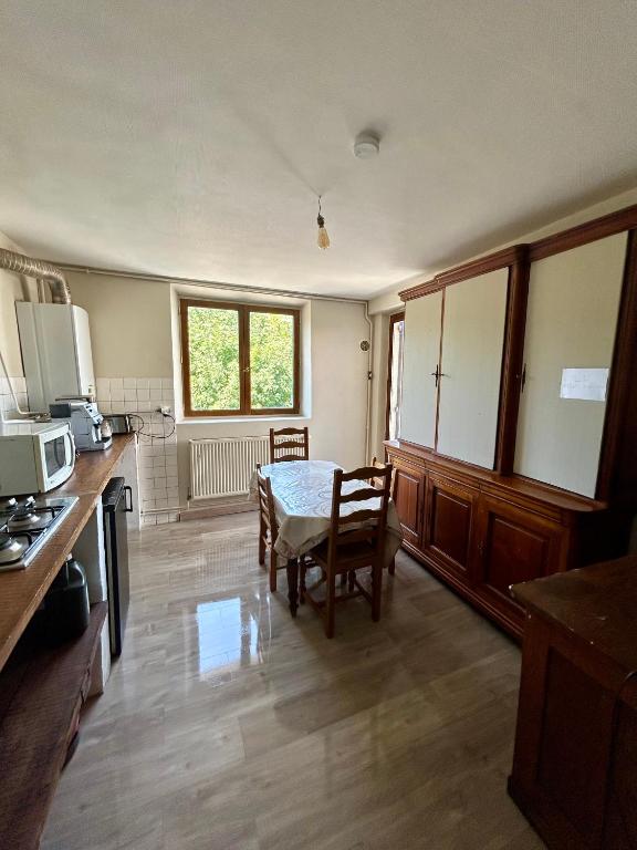 une cuisine avec une table et des chaises dans une pièce dans l'établissement 100metres du château au 116 Rue de la République vizille, à Vizille