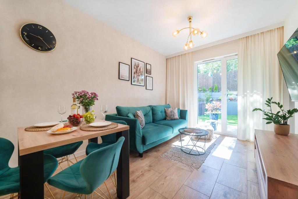 Una sala de estar con un sofá azul y una mesa. en LuxFlats Apartament LUX, en Jastrzębia Góra