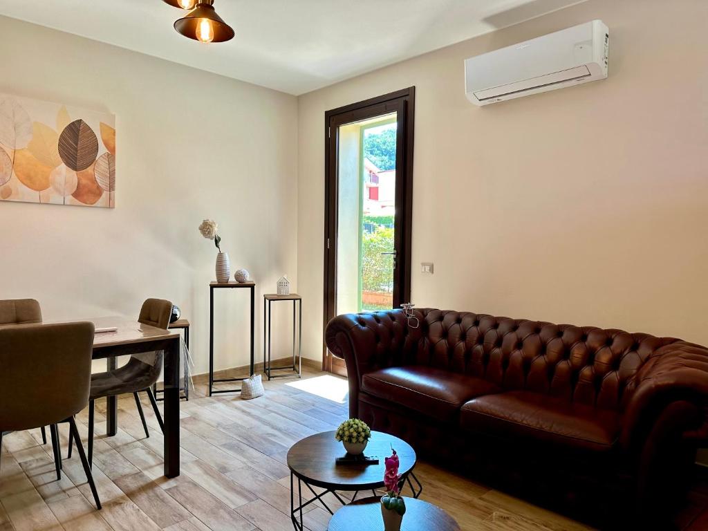 a living room with a leather couch and a table at Appartamento Relax nelle Vicinanze delle Terme in Monsummano