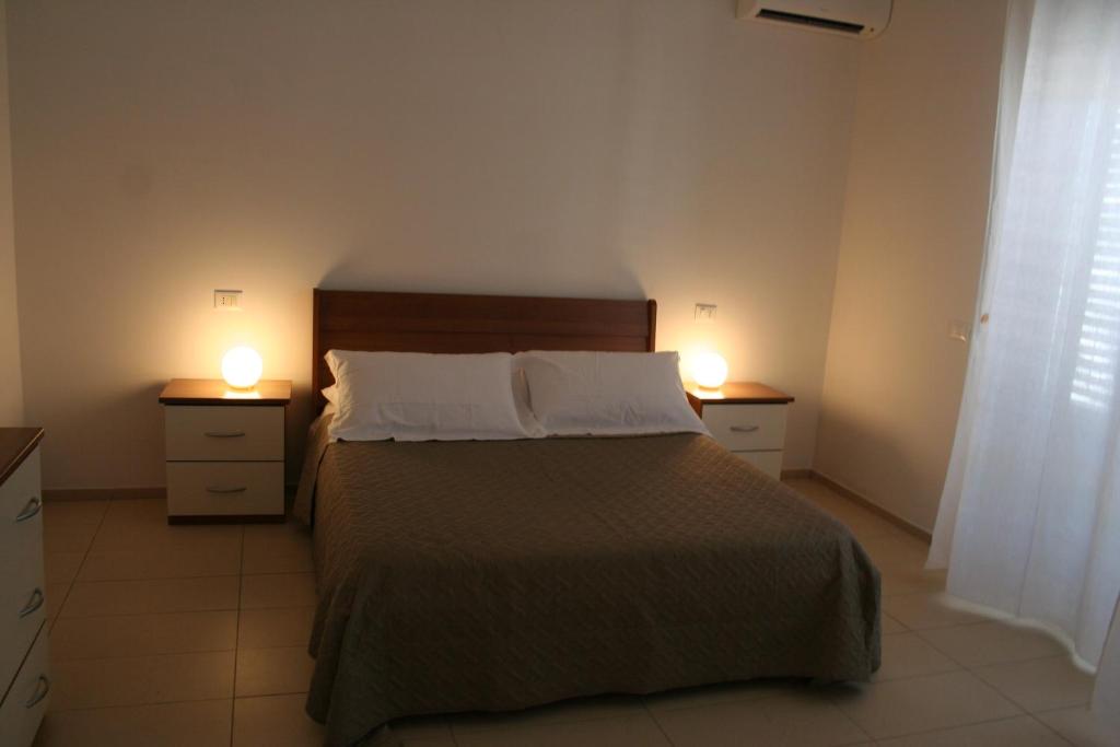 een slaapkamer met een bed en twee lampjes op twee nachtkastjes bij Case VacanzeRò in Ravenna