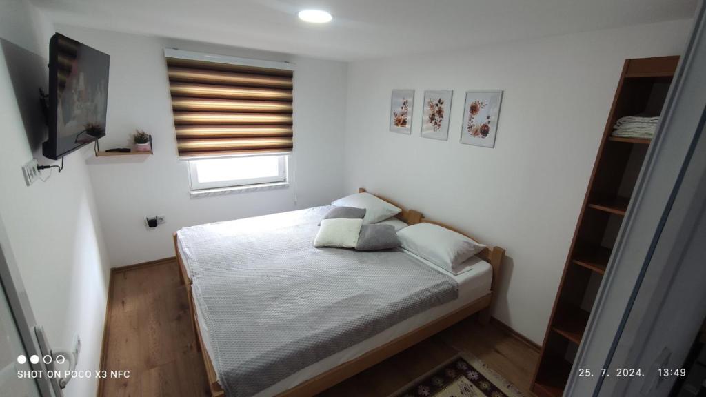 ein kleines Schlafzimmer mit einem Bett und einem Fernseher in der Unterkunft ZEMAN Old Town Apartment in Sarajevo