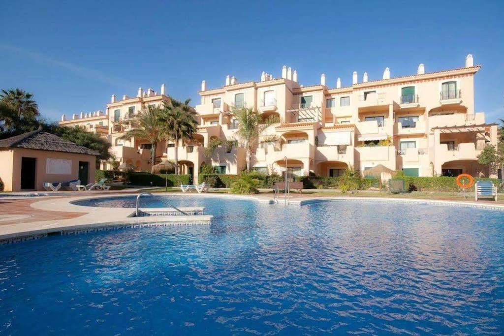 a large swimming pool in front of a building at Spacious duplex apartment families and couples in Manilva