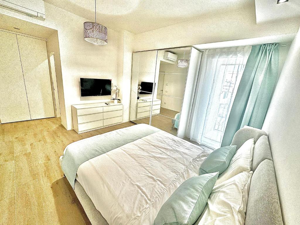 a bedroom with a bed and a large window at Tonfano Waterfront Penthouse in Marina di Pietrasanta