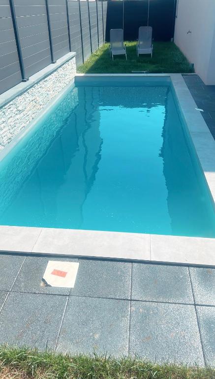- une piscine bleue avec 2 chaises dans l'établissement Villa Aqua Détente, à Ingersheim