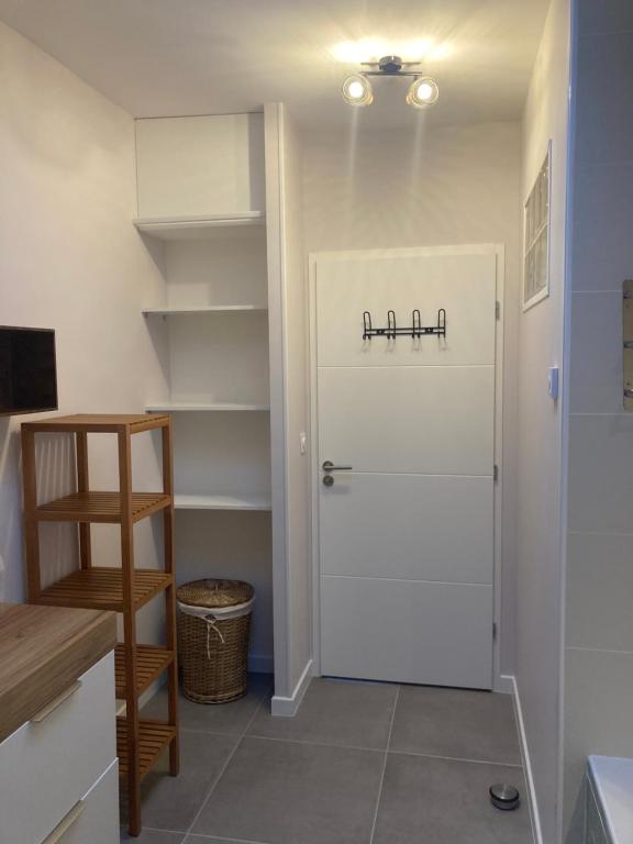 Cette chambre dispose d'une porte blanche et d'une étagère. dans l'établissement Maison plain-pied - Guidel, à Guidel