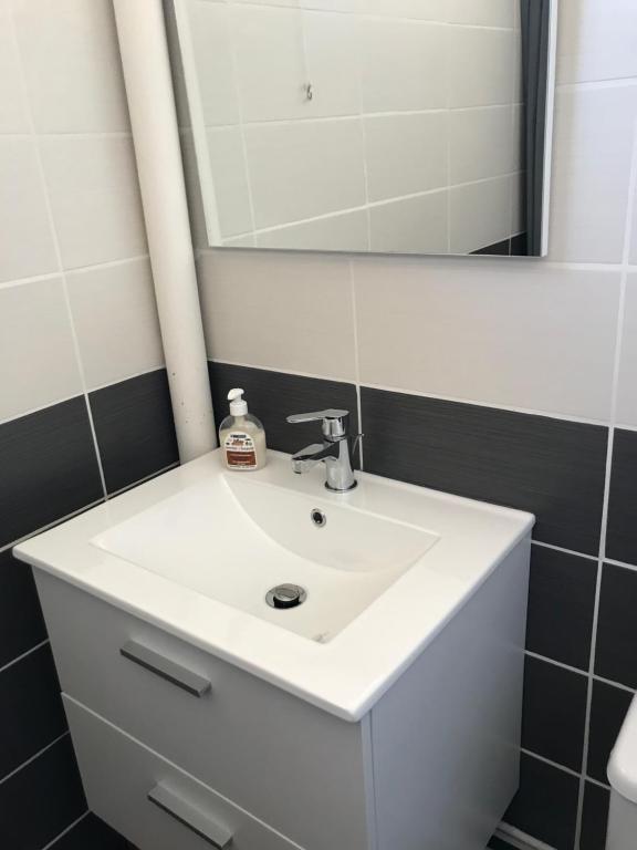 une salle de bain avec un lavabo blanc et un miroir dans l'établissement Studio, au Barcarès
