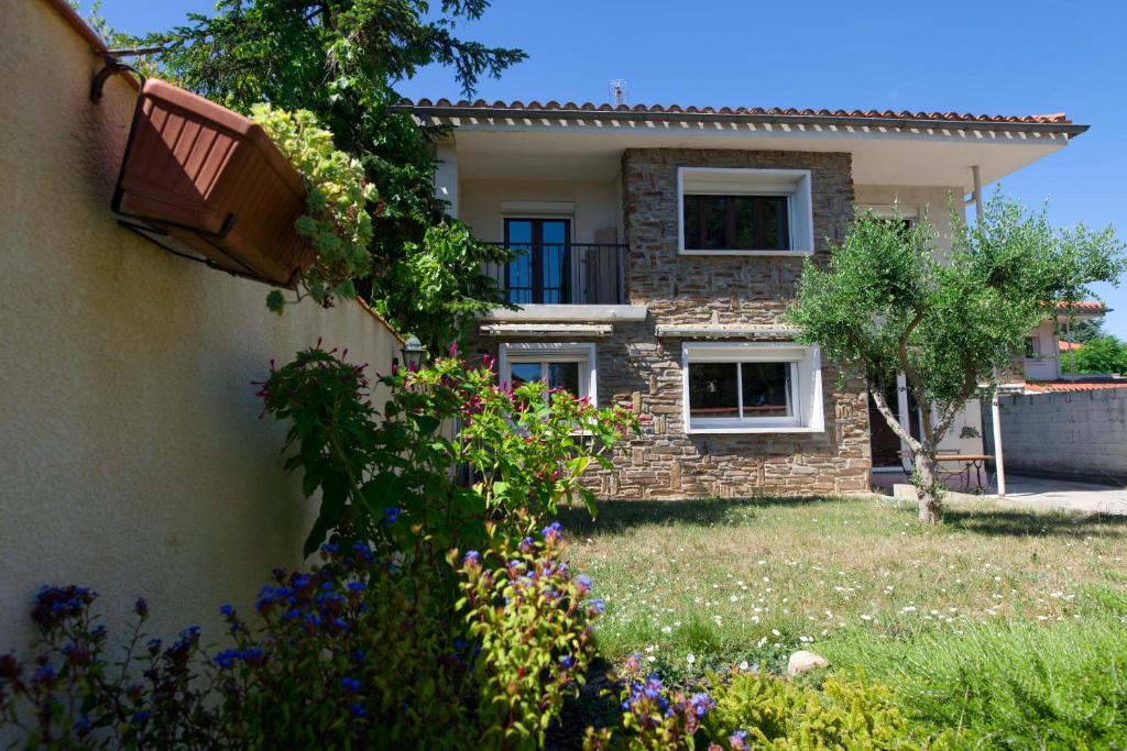 une maison avec une cour fleurie dans l'établissement Le Logis d'Aude, à Carcassonne