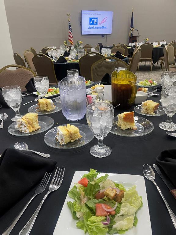 a table with plates of food and glasses of drinks at Plantation Inn in Houma