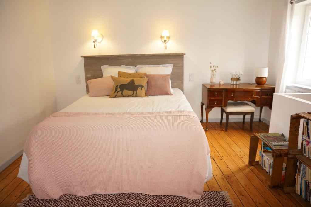 a bedroom with a large bed and a desk at Ma petite maison bretonne in Guimiliau