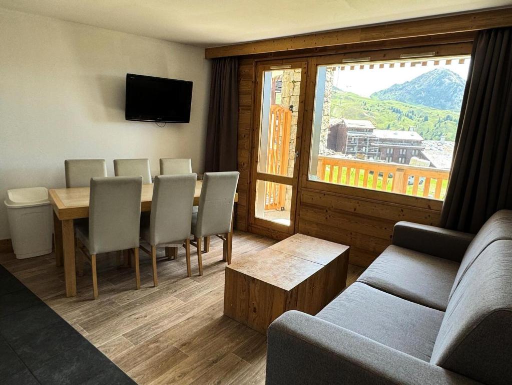 un salon avec une table, des chaises et un canapé dans l'établissement Résidence Le Centaure - 3 Pièces pour 6 Personnes 631, à Aime La Plagne