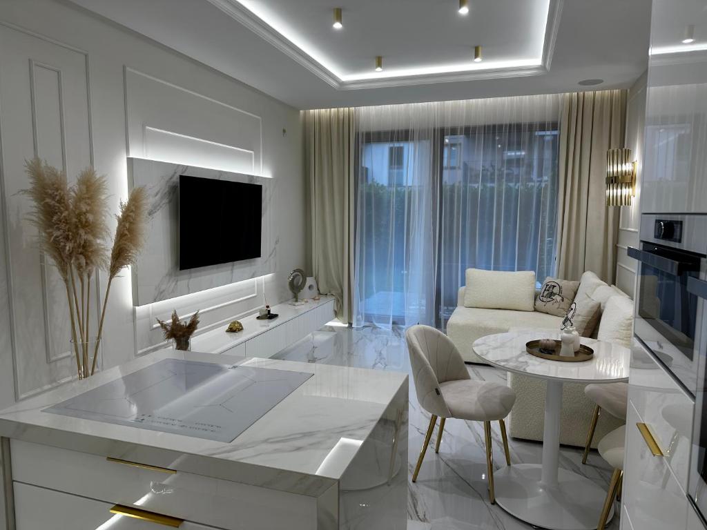 a kitchen and living room with a table and a couch at Sea Shell Stadium Brzeźno Beach in Gdańsk