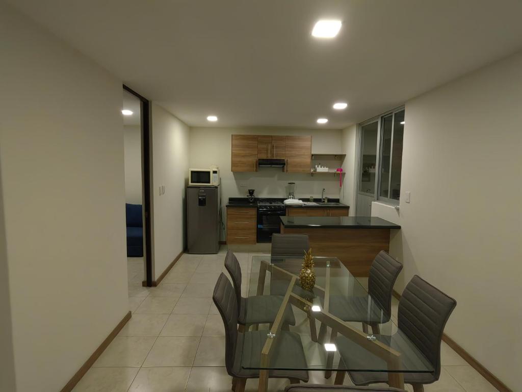 a kitchen and dining room with a glass table and chairs at Casa vacacional, en pueblo mágico Cholula in Cholula