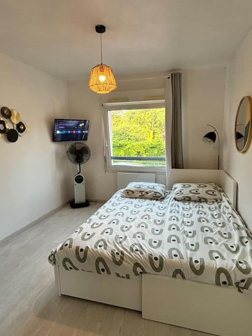 une chambre avec un lit, une fenêtre et une télévision dans l'établissement First, à Bourges