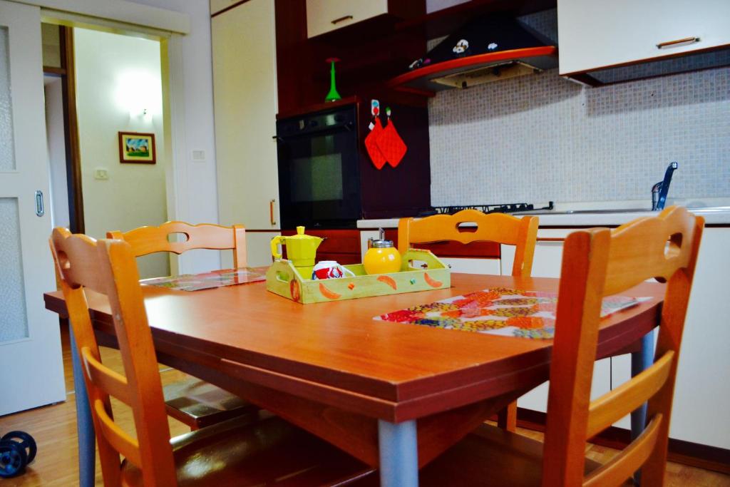 uma mesa de madeira numa cozinha com uma mesa e cadeiras em La Casa Di Olga em Matera