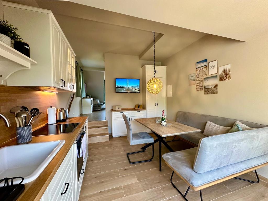 a kitchen and living room with a table and a couch at Ferienanlage Eldena Ferienwohnung 12 in Lobbe
