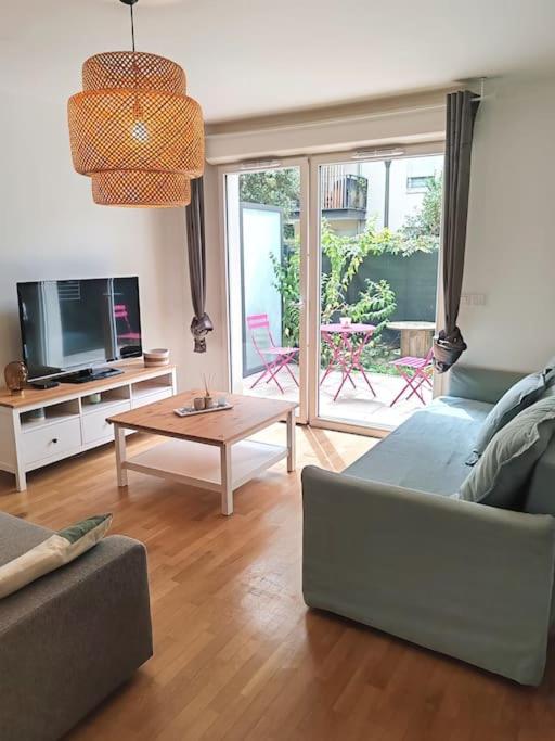 un salon avec un canapé et une table dans l'établissement Le Vitriot - Grand studio tout confort dans résidence récente - Aux portes de Paris, à Vitry-sur-Seine