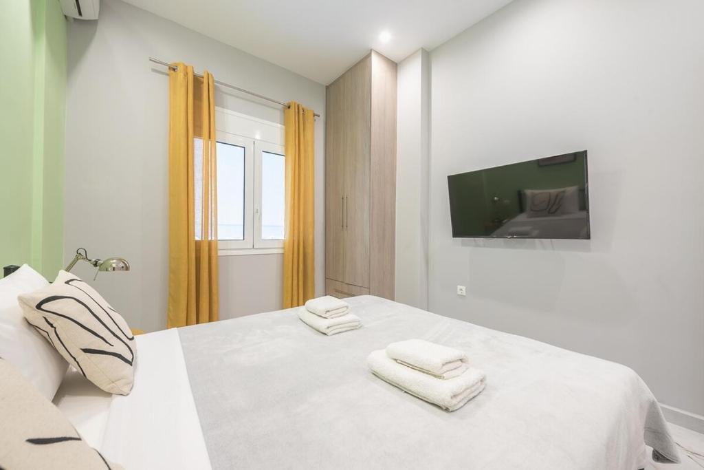 a bedroom with a white bed with towels on it at Athens Stay in Athens