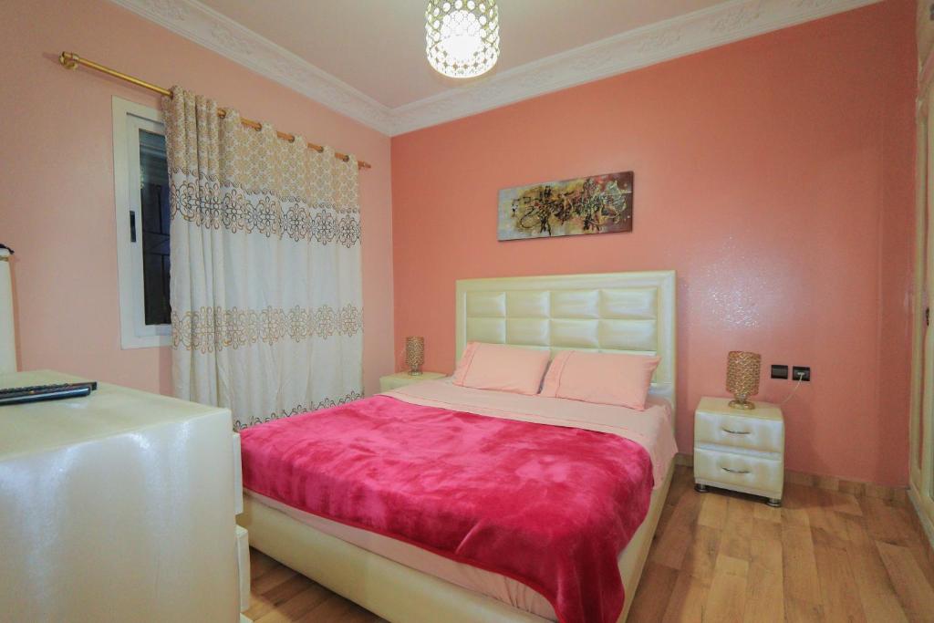 - une chambre avec des murs roses et un lit avec des draps roses dans l'établissement شقة في وسط المدينة هادئة ومناسبة للعائلات, à Charf