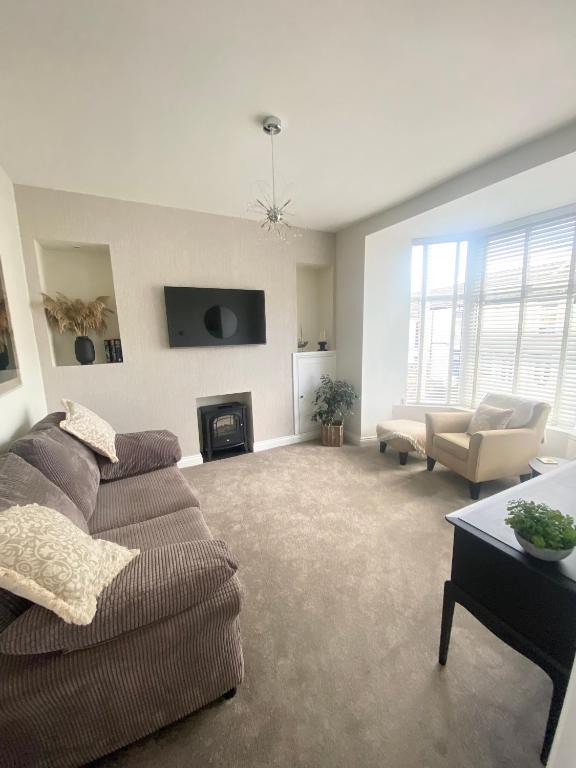 a living room with a couch and a fireplace at Spacious Town House in Aberdare