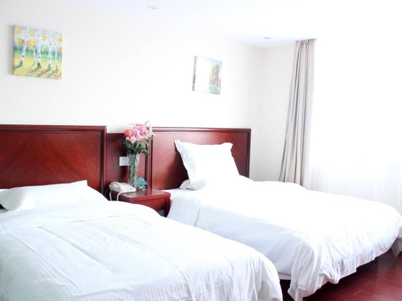 two beds in a room with white sheets at GreenTree Inn Jiangxi Yingtan Jiaotong Road Central Square Business Hotel in Yingtan