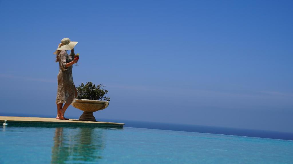 a woman standing on the edge of a swimming pool at Villa La Falaise in Oualidia