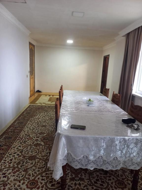 a dining room with a white table and chairs at Nicat in Quba