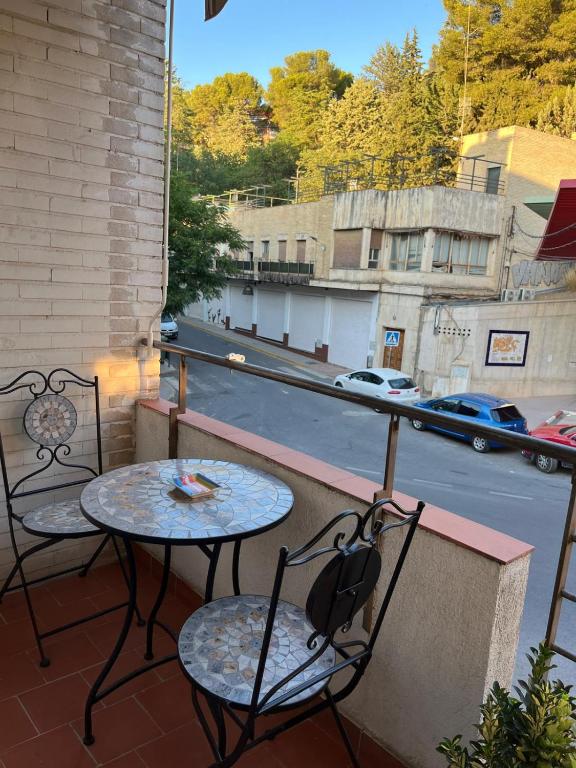 two tables and chairs on a balcony with a street at Titanic in Cazorla
