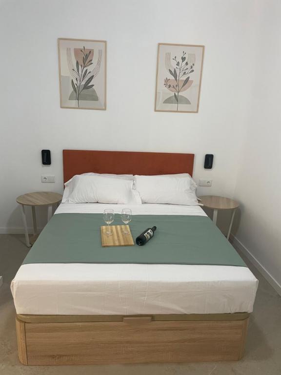 a bed with a bottle and two glasses on it at Galdós Flats by Vivo GC in Valencia