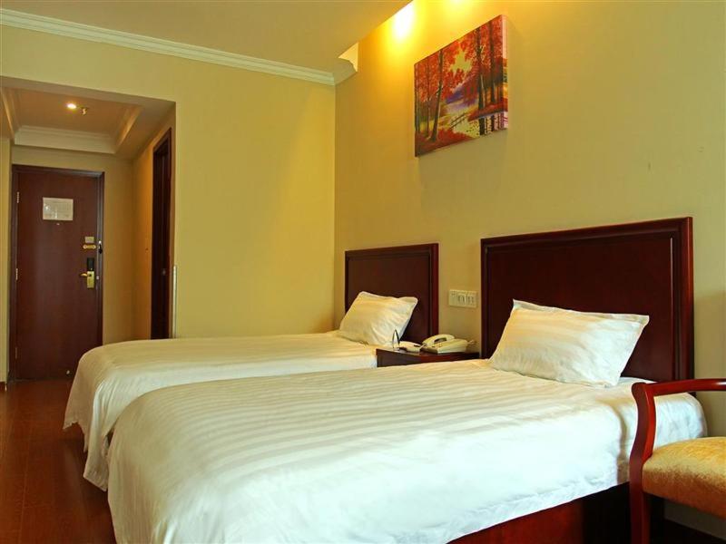 a hotel room with two beds and a telephone at GreenTree Inn Zhejiang Shaoxing Xinchang Buddha Express Hotel in Xinchang