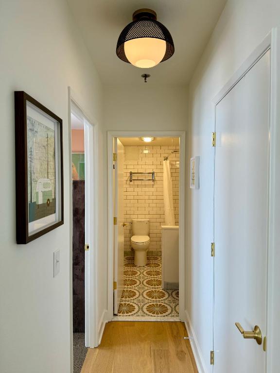 a hallway with a bathroom with a toilet and a shower at Norblad Hotel in Astoria, Oregon