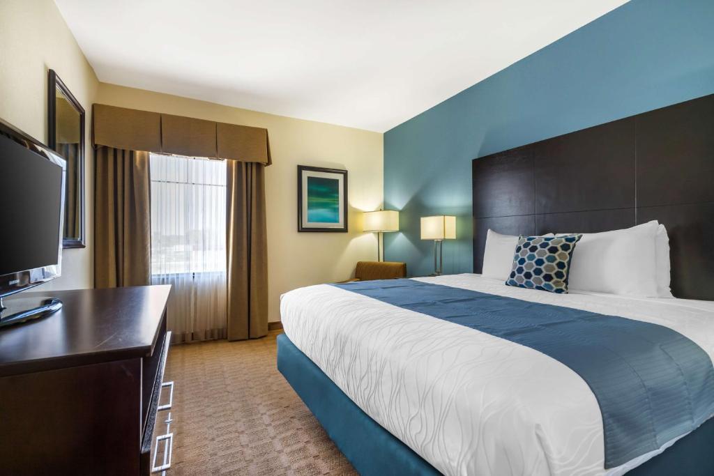 a hotel room with a large bed and a desk at Best Western Plus Lytle Inn and Suites in Lytle