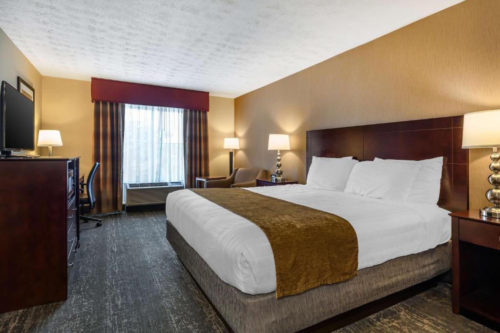 a hotel room with a large bed and a television at Best Western Braintree Inn in Braintree