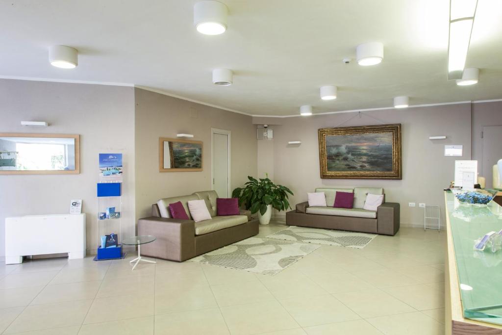 a waiting room with two couches and a table at Alma di Alghero Hotel in Alghero