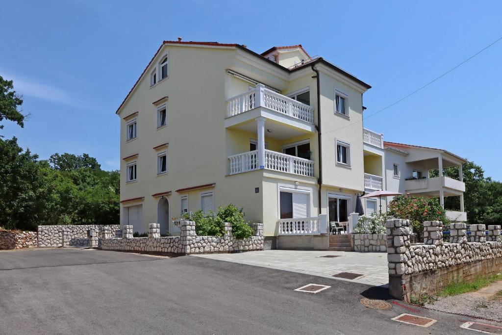 a large white house with a stone fence at Apartments with parking space Kostrena, Rijeka - 23422 in Kostrena