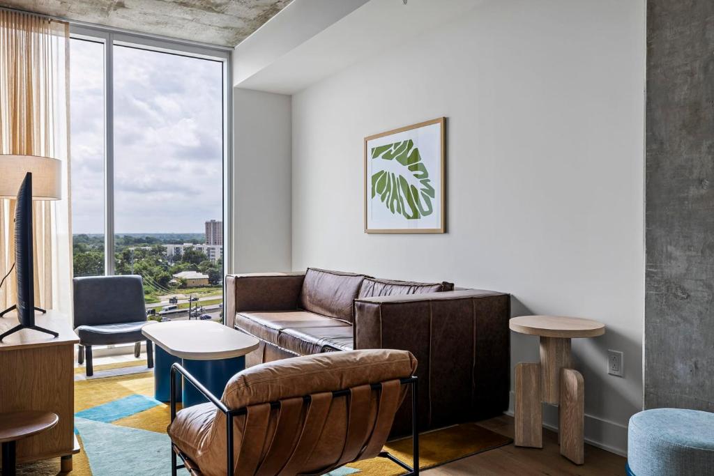 een woonkamer met een bank en een tafel bij Modern 1BR Condo on Rainey St - Pool & Views in Austin