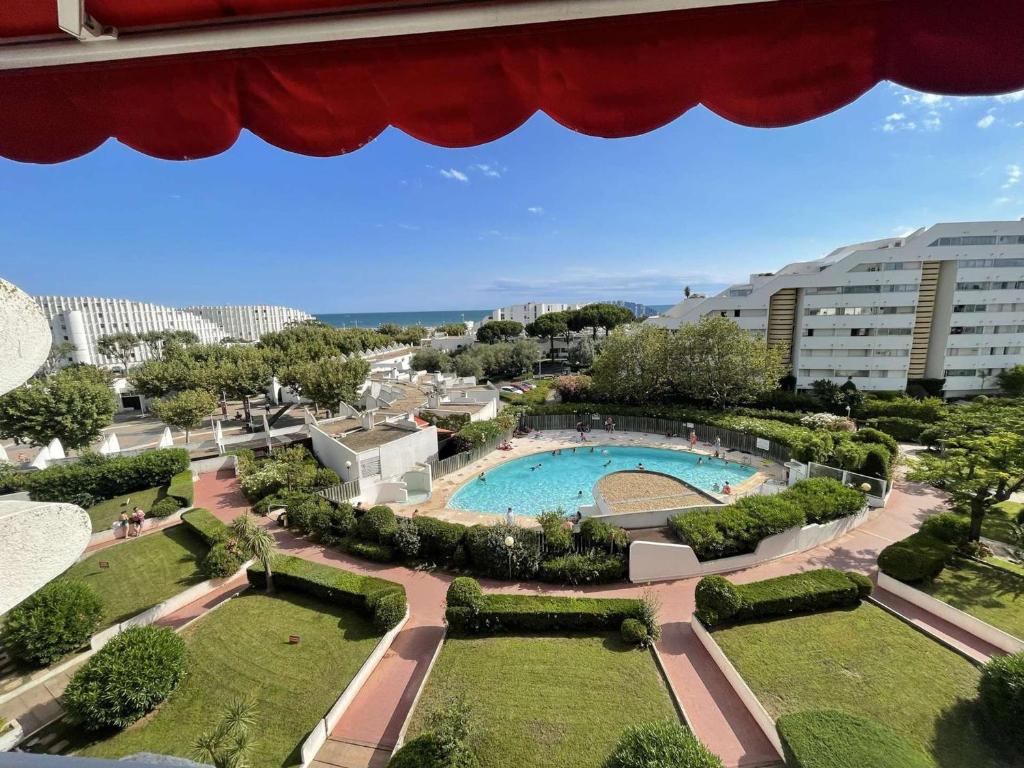 - une vue sur la piscine dans un parc avec des bâtiments dans l'établissement Appartement 3 Pièces, Piscine, Proche Plage, Wi-Fi, Garage - FR-1-328-269, à La Grande Motte