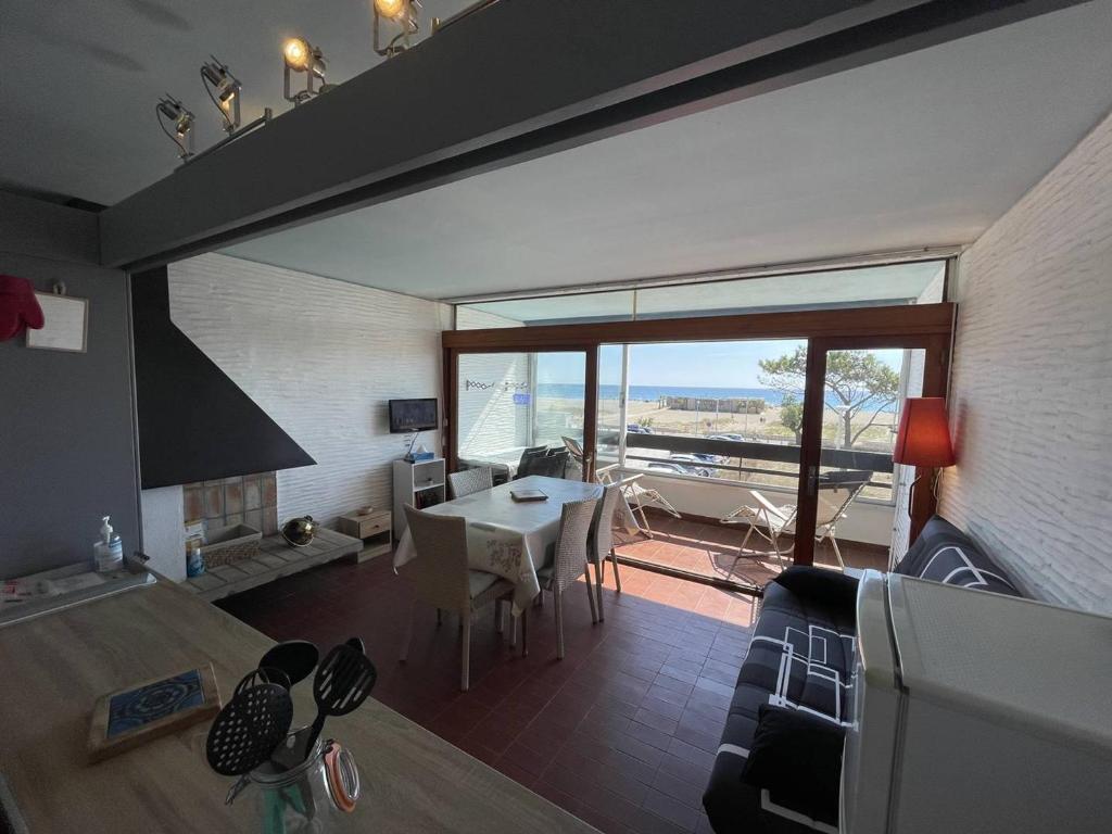 - un salon avec une table et une chambre avec vue dans l'établissement Saint-Cyprien : T2 confortable en bord de mer avec parking et animaux admis - FR-1-106-106, à Saint-Cyprien