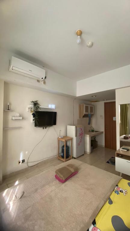 a living room with a rug and a tv on the wall at Mares int in Sugutamu Dua