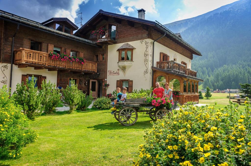 un groupe de personnes sur une calèche tirée par des chevaux devant une maison dans l'établissement Art Apartments Casa Lapis, à Livigno