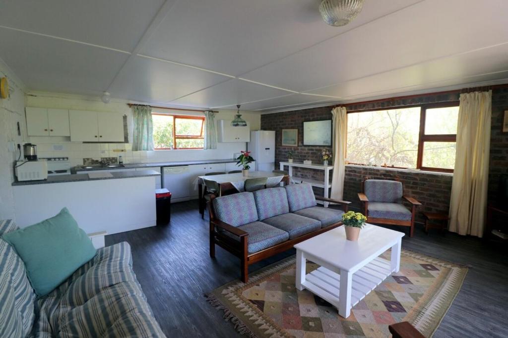 een woonkamer met een bank en een tafel bij Shalom House in Arniston