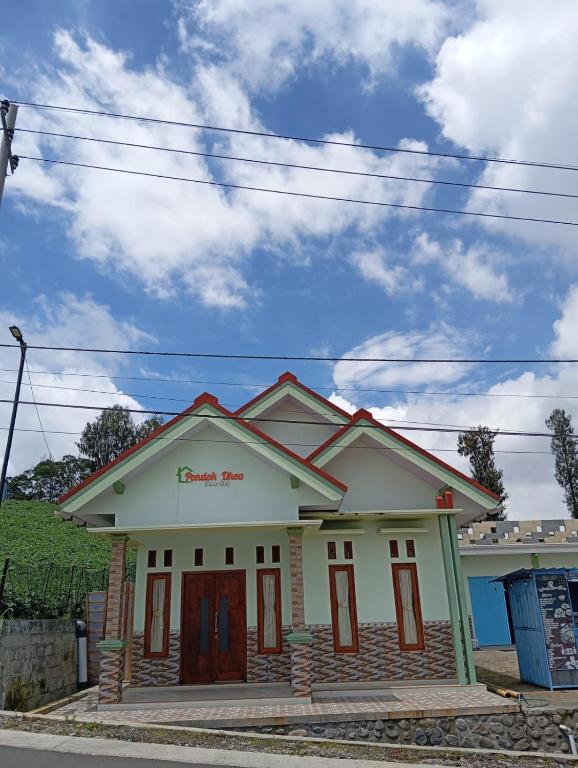 a small white house with a red roof at Dhea Homestay Bromo in Probolinggo