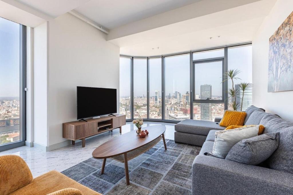 a living room with a couch and a tv at Beautiful Bright Deluxe 1bd Condo Poolviews! #311 in Istanbul