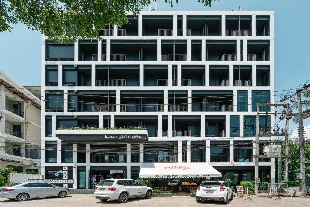 a white building with cars parked in front of it at Blu Monkey Hub and Hotel Phuket Town- Free All Day Coworking space in Phuket Town