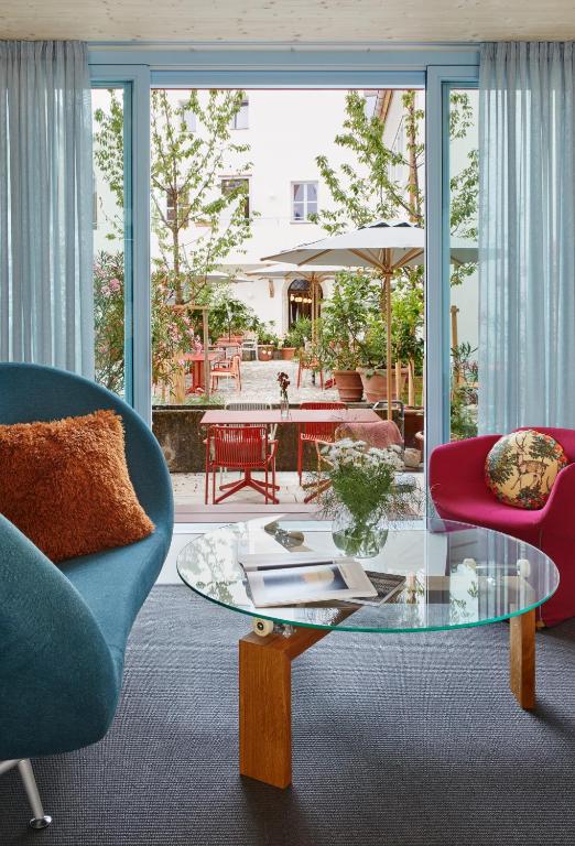 a living room with two chairs and a glass table at Engelwirt Hotel & Apartments in Berching