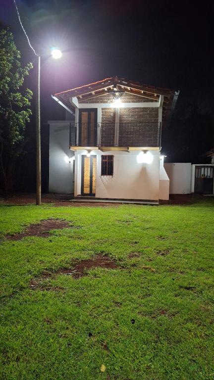 a house with a street light and a green yard at Cabañas De La Vega in Tomatlán