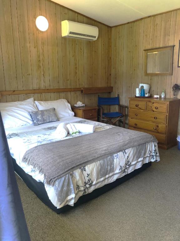 a bedroom with a large bed and a dresser at Yarrabin Country Retreat in OʼConnell